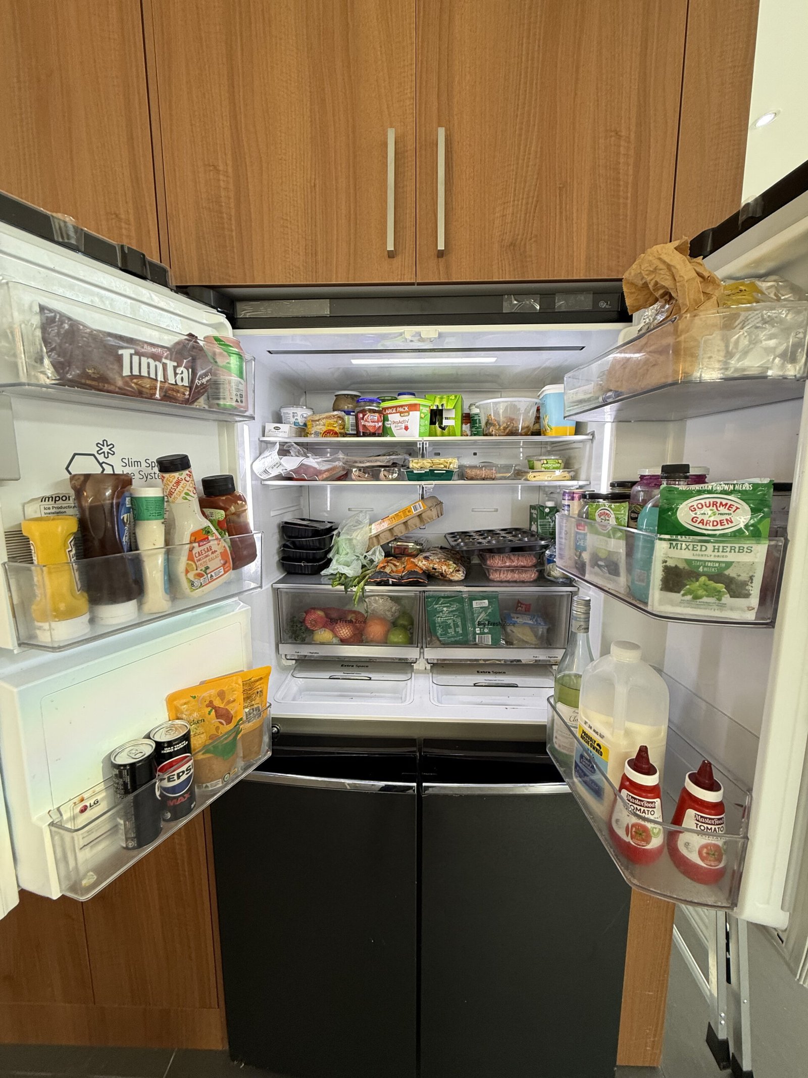 Fully stocked fridge interior before deep cleaning